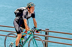 自転車で海辺を走る男性